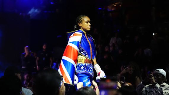 Natasha Jonas posing⁣ with her championship belts.