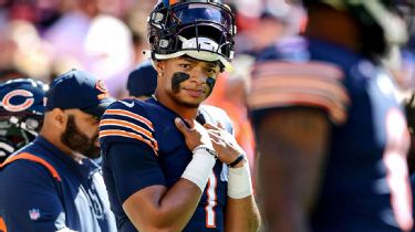 A Chicago Bears fan holds a quarterback Justin Fields jersey