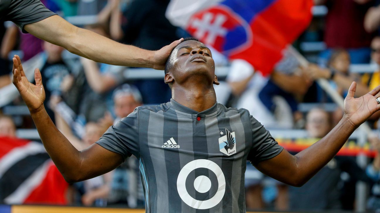 Vancouver Whitecaps' Alphonso Davies covers his head with his jersey as he  pauses on the field after Vancouver was defeated 2-1 by FC Dallas during an  MLS soccer match in Vancouver, on