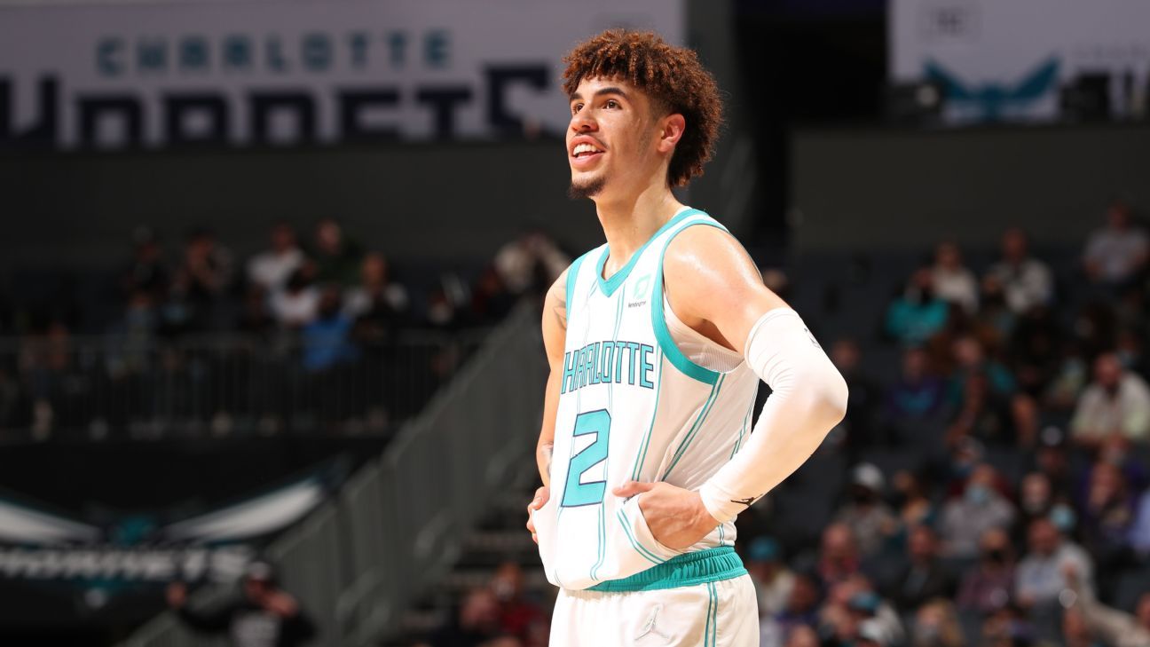 Charlotte Hornets guard LaMelo Ball (2) and Miami Heat forward Jimmy Butler  (22) chase after a loose ball with his shoes displayed during the second  half at the Spectrum Center.