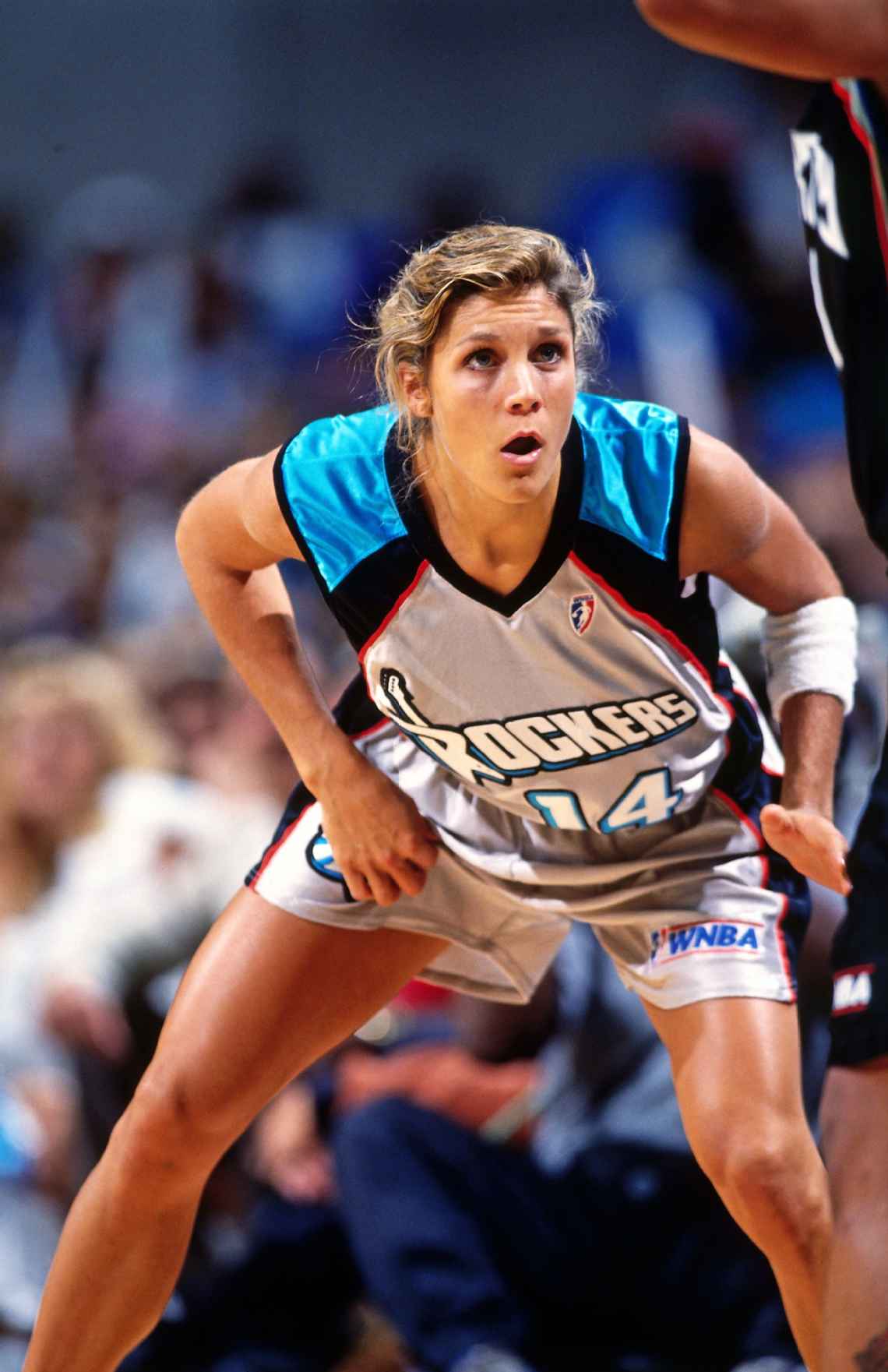 Jenny Boucek standing on a basketball court